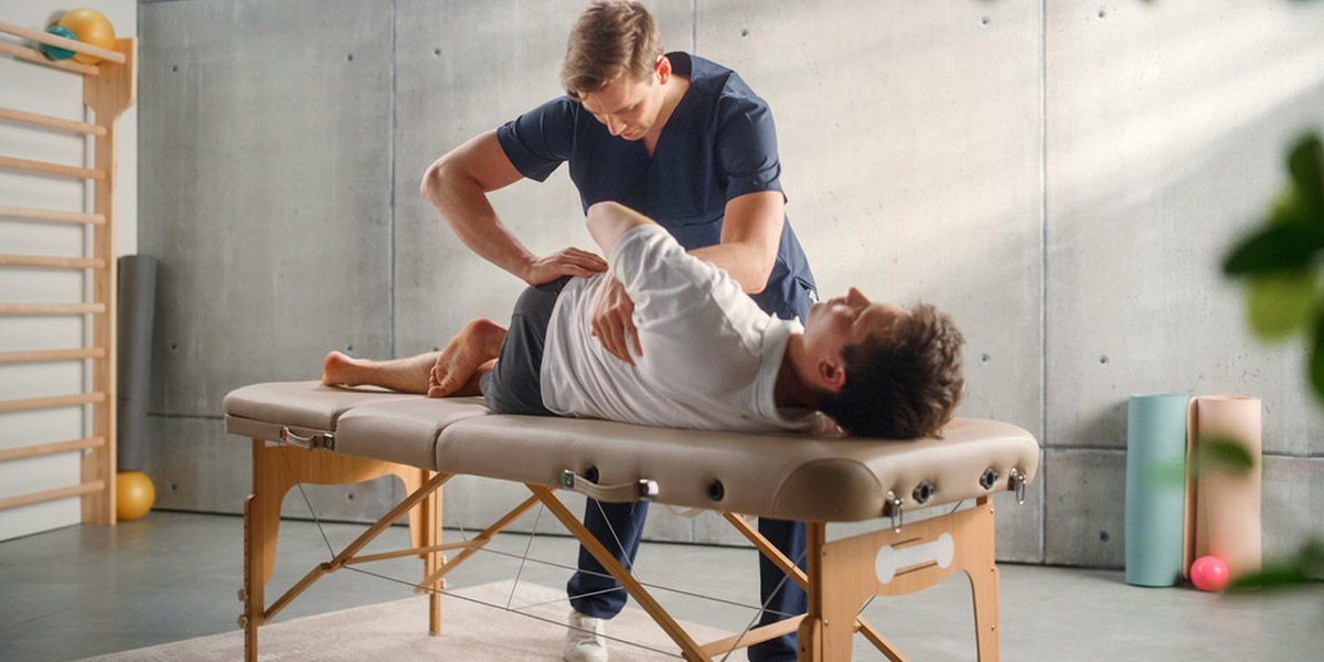 Fizyoterapist klinik ortamında hastaya manuel terapi uyguluyor